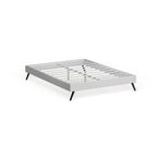 Cama de plataforma Queen tapizada en vinilo blanco con patas oblicuas